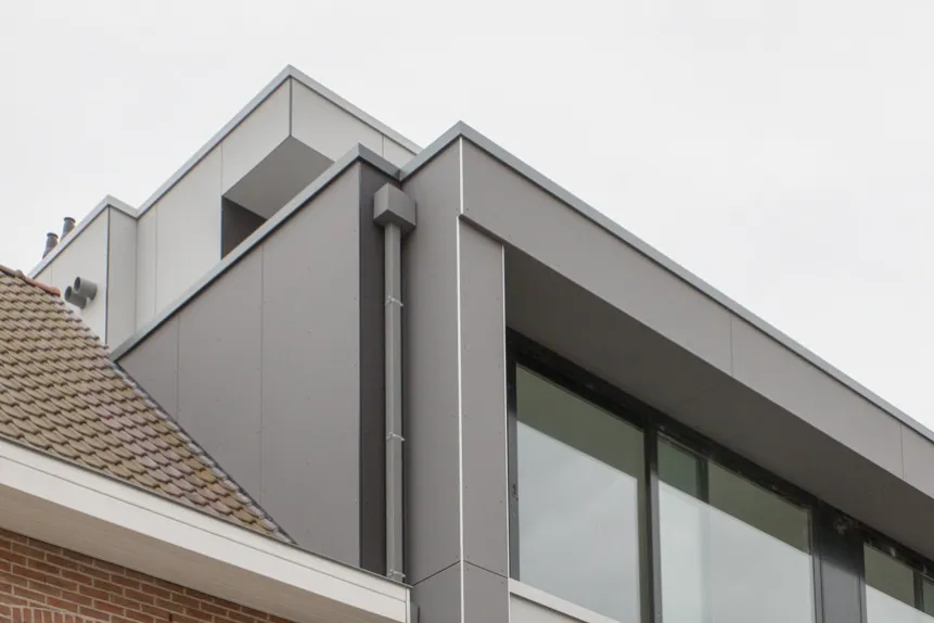 Detailopname van de dakrand en gevelbekleding in grijze panelen, vakkundig afgewerkt door Dakwerken De Haes in Putte, Alice Nahonstraat.